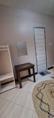 a room with a wooden table and a wall at African Royal Homestay karatu in Karatu
