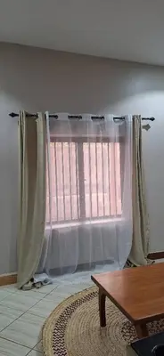 a window with curtains in a room with a table at African Royal Homestay karatu in Karatu