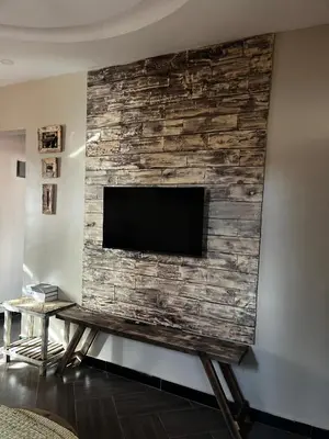 a flat screen tv on a stone wall at Cj VILLA in Karatu