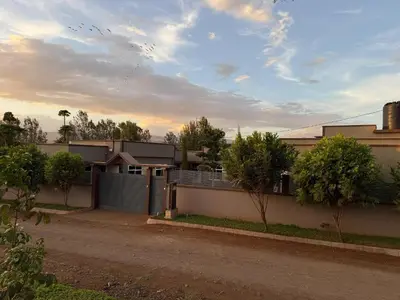 a house with a fence in front of a street at Cj VILLA in Karatu