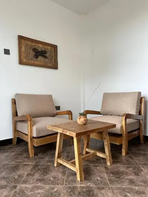 two chairs and a coffee table in a room at Cj VILLA in Karatu