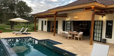 a house with a pool and a patio with a table and chairs at Asama House in Usa