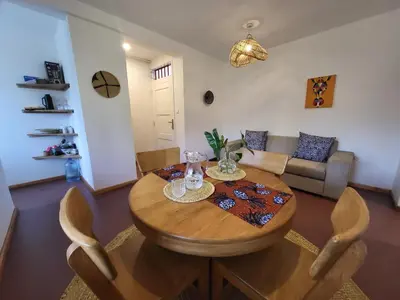 a living room with a wooden table and a couch at House, towncenter, near to all good restaurants, in Arusha