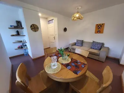 a living room with a wooden table and chairs at House, towncenter, near to all good restaurants, in Arusha