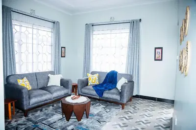 a living room with two couches and a coffee table at FM Moshono Apartment in Arusha