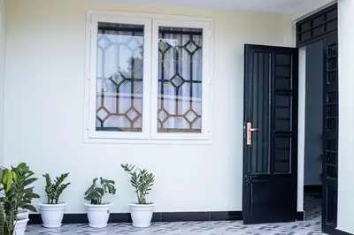 a door with potted plants in front of a house at FM Moshono Apartment in Arusha