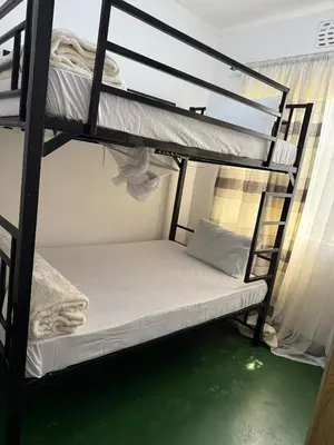 two bunk beds in a room with a green floor at At Chilala's in Arusha
