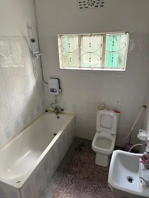 a bathroom with a tub and a toilet and a sink at At Chilala's in Arusha