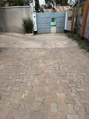 a stone driveway in front of a building with a gate at At Chilala's in Arusha