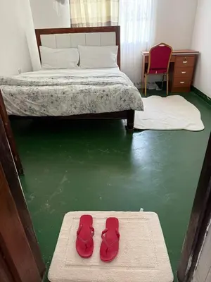 a pair of red shoes sitting on a rug in a bedroom at At Chilala's in Arusha