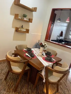 a dining room with a wooden table and chairs at Famurest in Nkoanrua