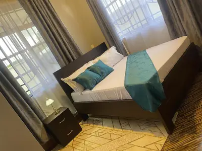 a small bed with blue pillows in a bedroom at Famurest in Nkoanrua