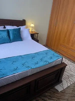 a bedroom with a bed with blue pillows at Famurest in Nkoanrua