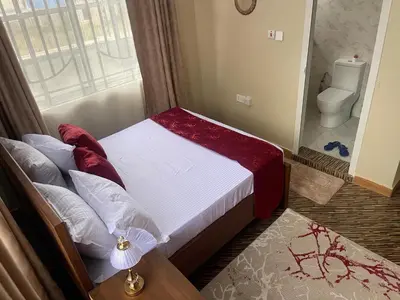 a small bedroom with a bed and a toilet at Famurest in Nkoanrua