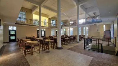 a large room with tables and chairs in a building at Kilimanjaro Village Hotel