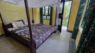 a bedroom with a bed with a canopy at Kilimanjaro Village Hotel