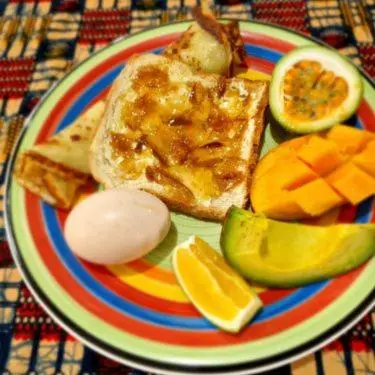 a plate of food with eggs and toast and fruit at Kilimanjaro Village Hotel