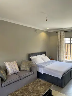 a bedroom with a bed and a couch at Casabella stay in Arusha