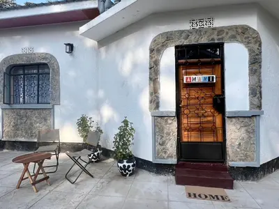 a door to a house with two chairs and a table at John's Place in Arusha