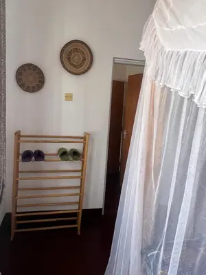 a bedroom with a bed and a clock on the wall at John's Place in Arusha
