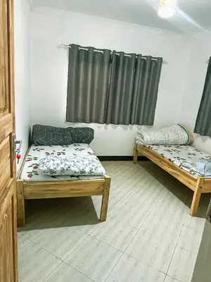 a living room with two beds and a window at njiro one in Arusha