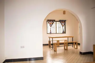 a table and bench in a room with a window at njiro one in Arusha