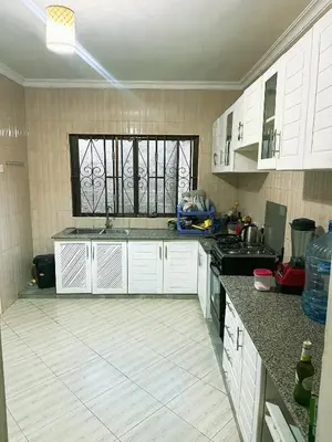 a kitchen with white cabinets and a window at njiro one in Arusha
