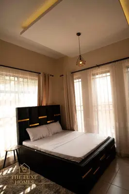 a bedroom with a large bed in a room with windows at The Luxe Homes 3BR Luxury Stay in Tuvaila