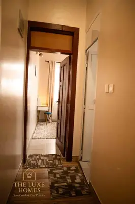 a hallway with a door to a room with a table at The Luxe Homes 3BR Luxury Stay in Tuvaila