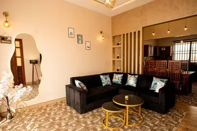 a living room with a black couch and a table at The Luxe Homes 3BR Luxury Stay in Tuvaila