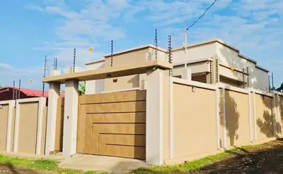 a house with a gate and a garage at The Luxe Homes 3BR Luxury Stay in Tuvaila