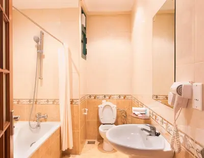 a bathroom with a sink and a toilet and a tub at Gold Crest Hotel - Arusha in Arusha