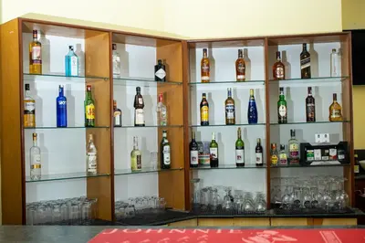 a shelf filled with lots of bottles of alcohol at Gold Crest Hotel - Arusha in Arusha