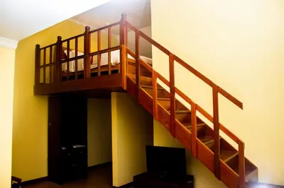 a wooden staircase in a room with a tv at Gold Crest Hotel - Arusha in Arusha