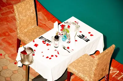 a table with a white table cloth with flowers on it at Gold Crest Hotel - Arusha in Arusha