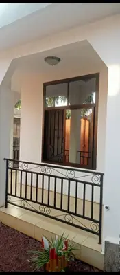 a mirror on the side of a house with a balcony at Latricia Home Stay in Moshi