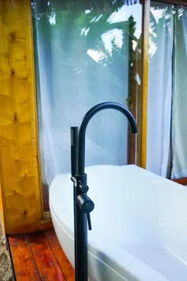 a black umbrella standing next to a bath tub at Kilimani Villa in Moshi