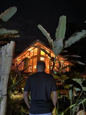 a man standing in front of a house at night at Kilimani Villa in Moshi