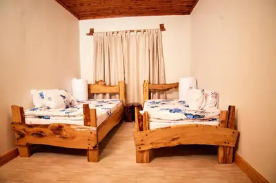 a bedroom with two twin beds and a window at Kienyeji Wooden Rest Arusha in Nkoanrua