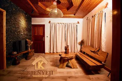 a living room with a table and a tv at Kienyeji Wooden Rest Arusha in Nkoanrua