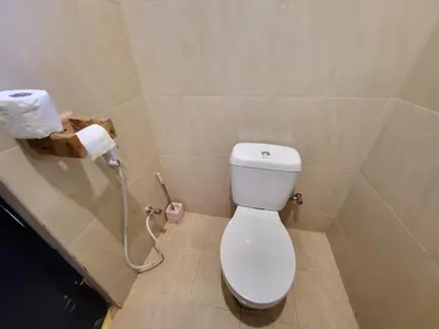 a bathroom with a toilet and a roll of toilet paper at Jangwani Riverview Suits in Mto wa Mbu