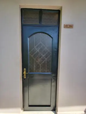 a blue door in a white wall at Jangwani Riverview Suits in Mto wa Mbu
