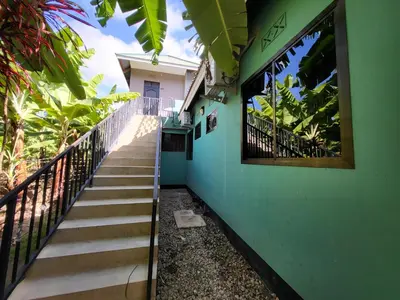 a stairway leading up to a house with green walls at Jangwani Riverview Suits in Mto wa Mbu