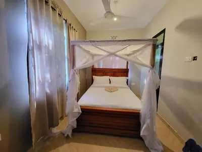 a bedroom with a canopy bed in a room at Jangwani Riverview Suits in Mto wa Mbu