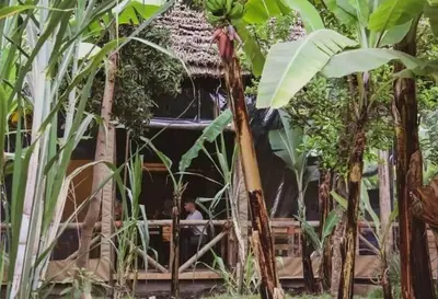 a man standing in a hut in the jungle at Jangwani Riverview Suits in Mto wa Mbu