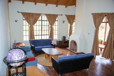 a living room with blue furniture and a fireplace at GreenNest Ranche in Arusha