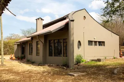 a small white house with a roof at GreenNest Ranche in Arusha