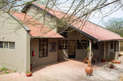 a house with a red roof and a patio at GreenNest Ranche in Arusha