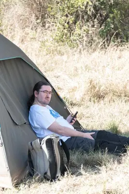 a man sitting in a tent with a backpack at Twende Africa Tours in Moshi