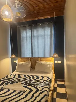 a bedroom with a zebra print bed with a window at Woodland villa in Arusha